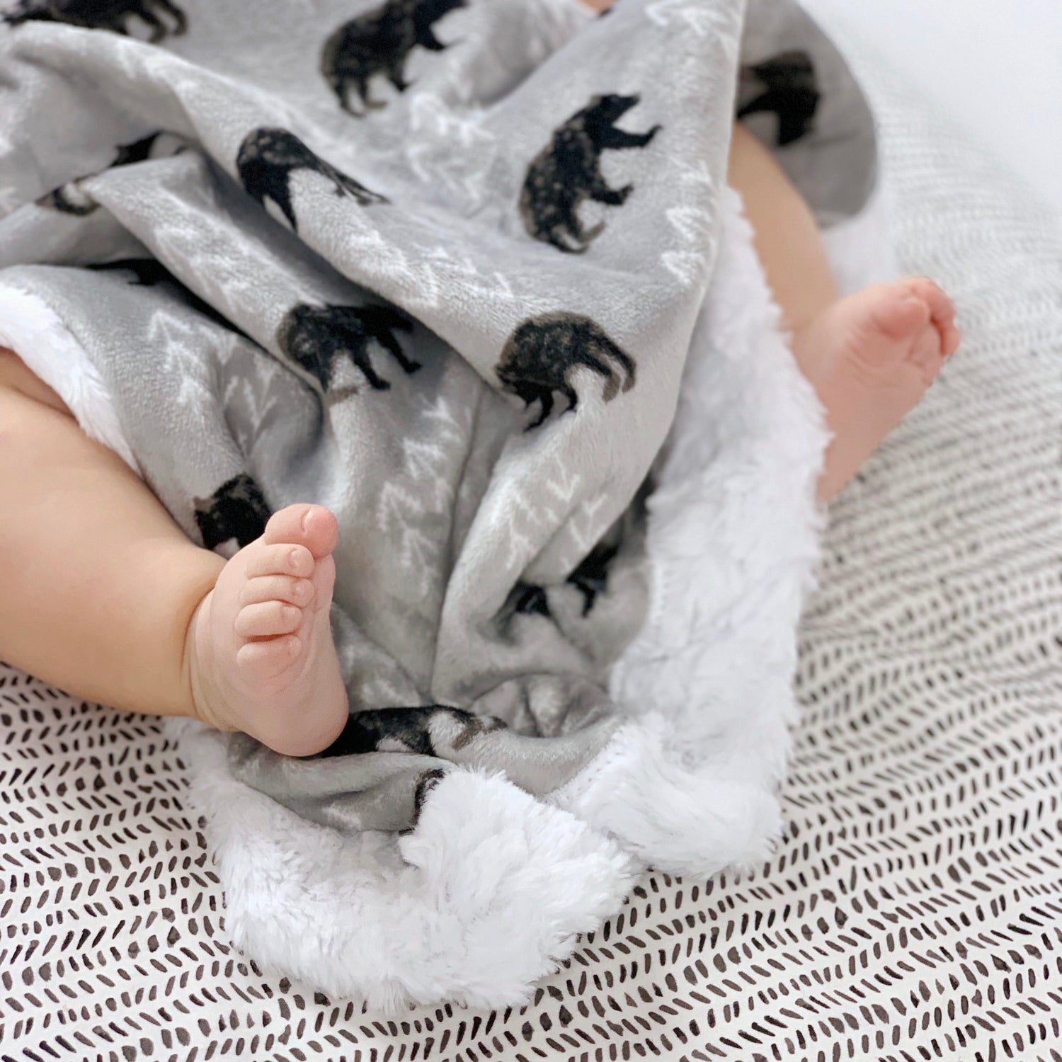 baby toes wrapped about a cozy minky blanket with bears