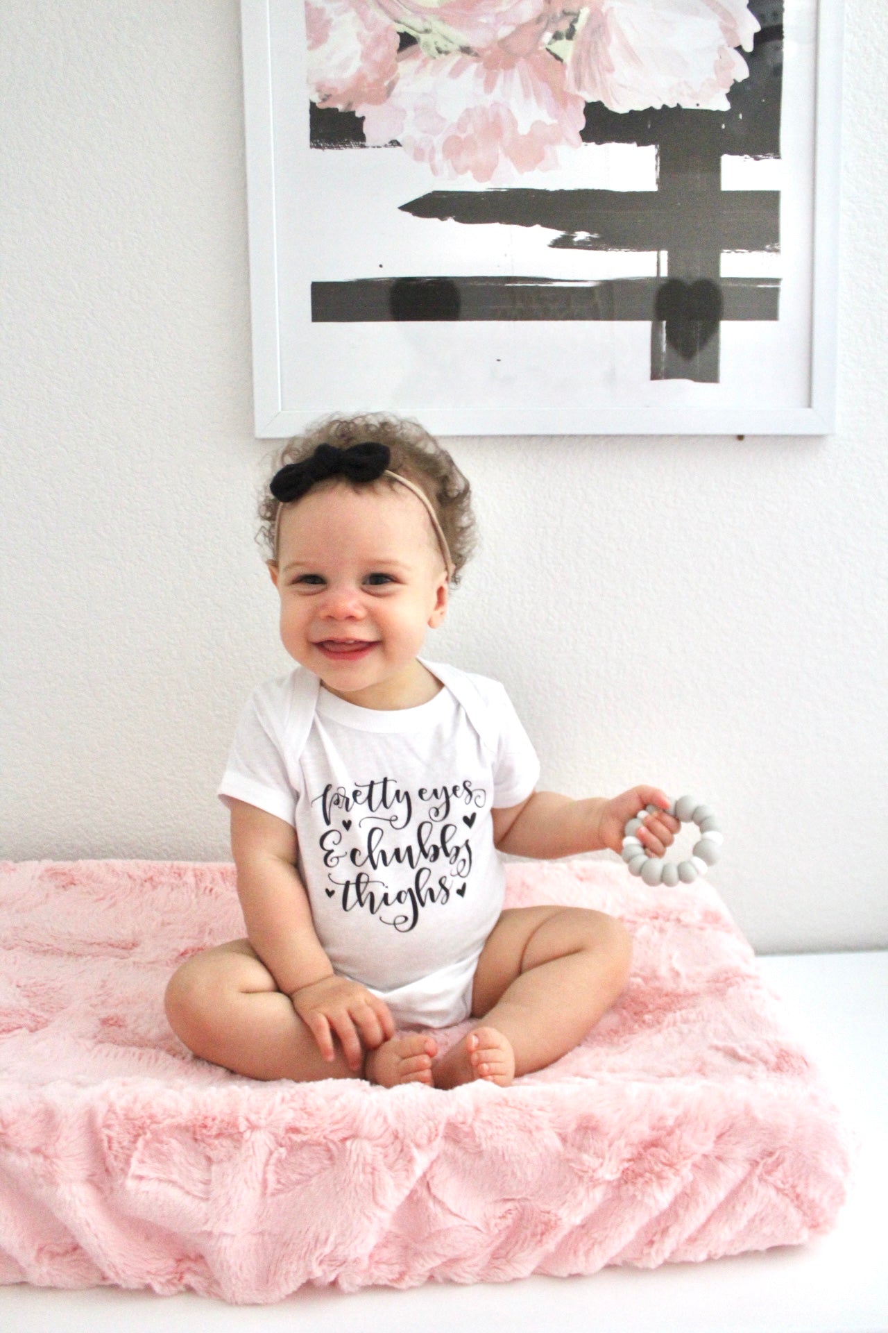 baby sitting on a peachy pink minky changing pad cover