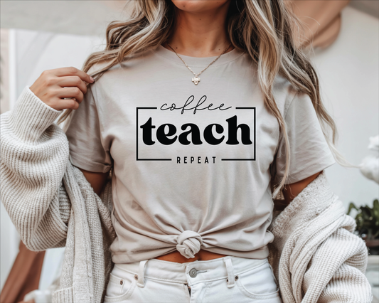 A woman wearing a light beige graphic t-shirt with the words 'coffee teach REPEAT' printed in black. She has a chunky knit cream cardigan draped off her shoulders and is wearing white jeans.